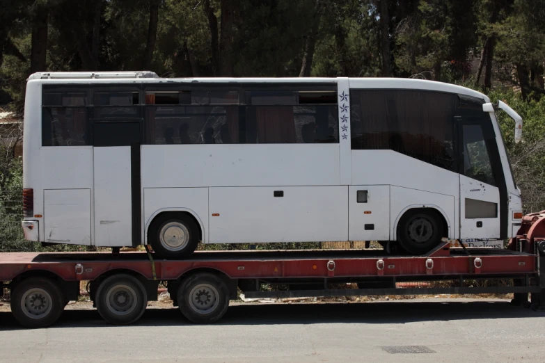 a white bus being towed on the road