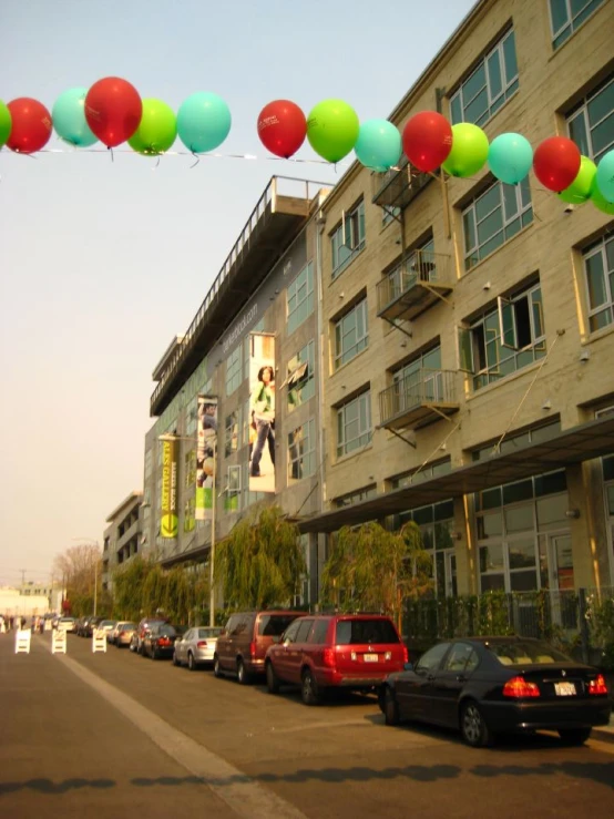 several cars parked along the road next to some tall buildings