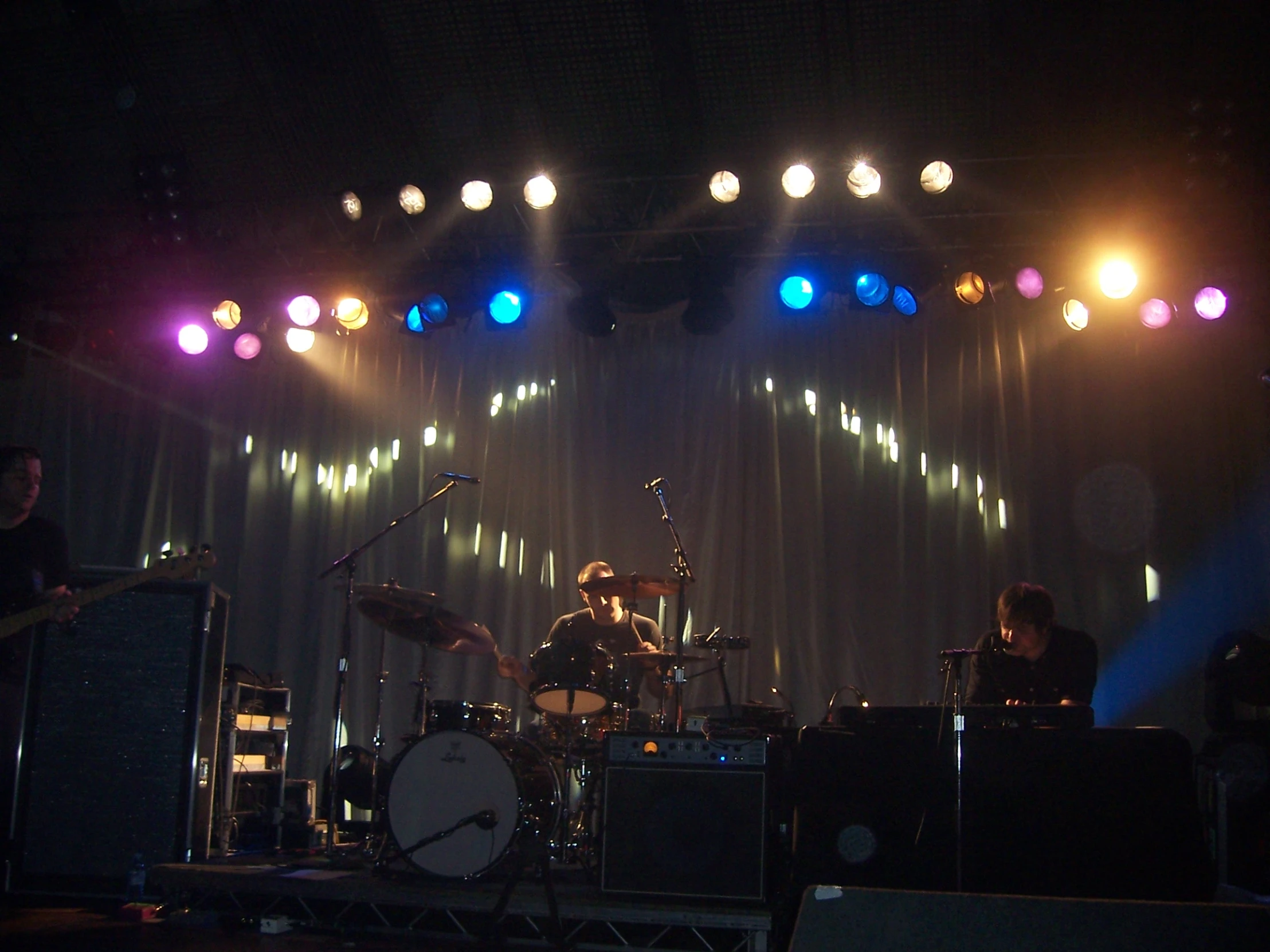 band performing on stage with bright lights above