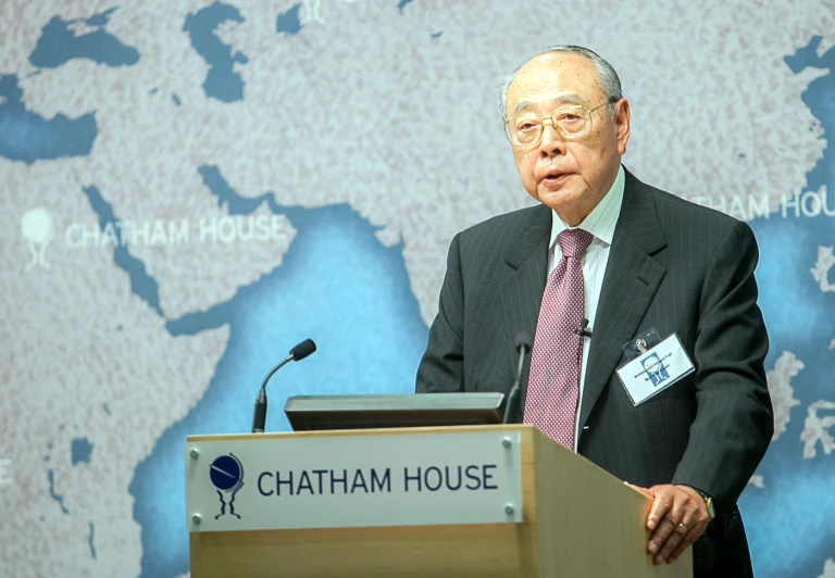 man with glasses giving a speech at a podium