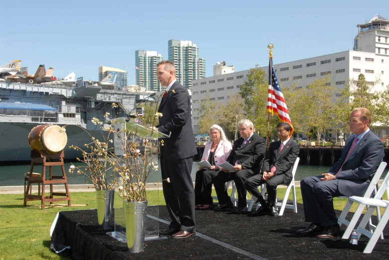 two men in suits standing near a microphone during a ceremony