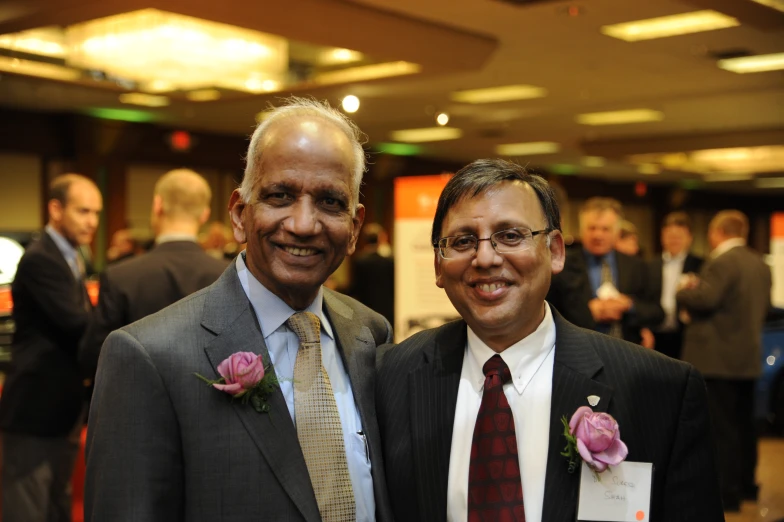 two men standing next to each other in suits