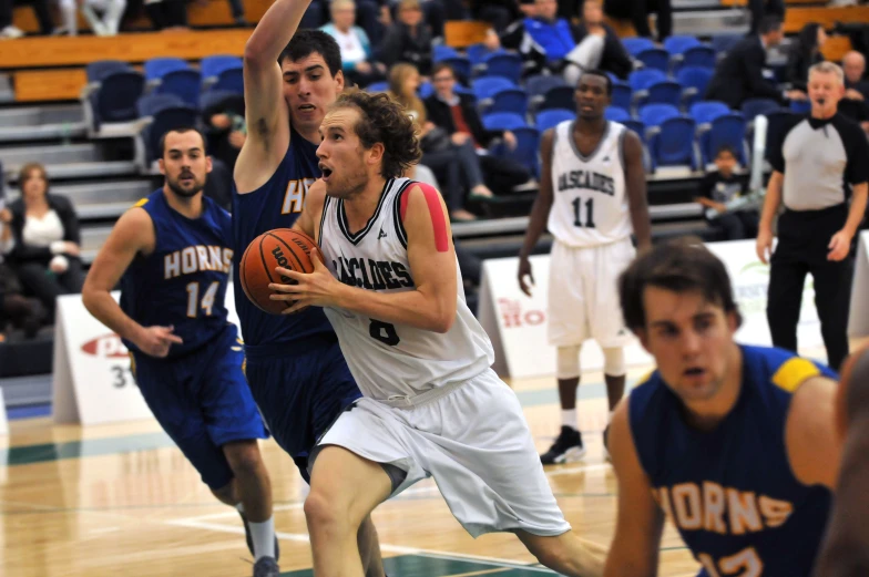 basketball players on court during match in indoor arena