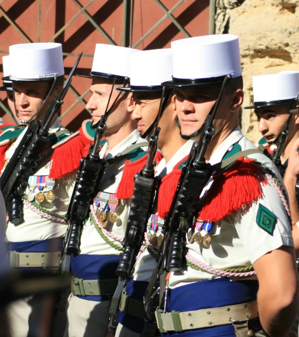 a row of men in uniforms holding guns