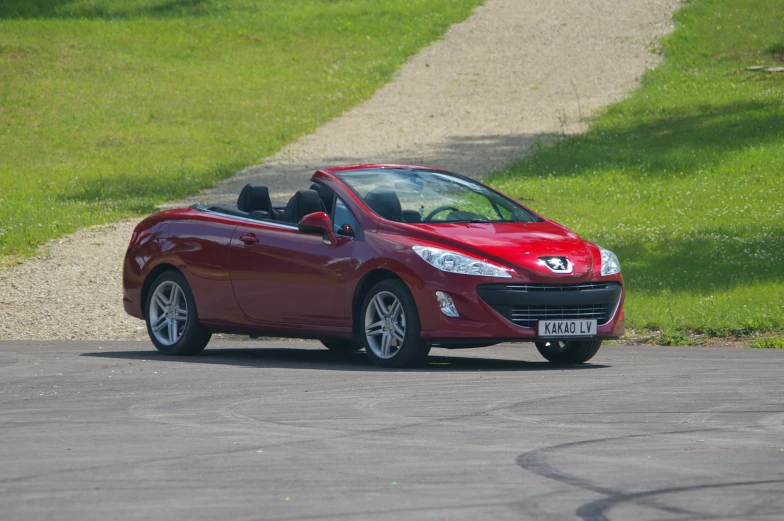 a small red compact car parked on the street