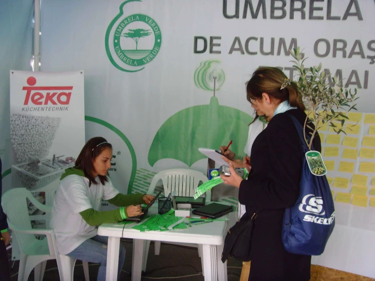 two girls are talking over soing in front of a table