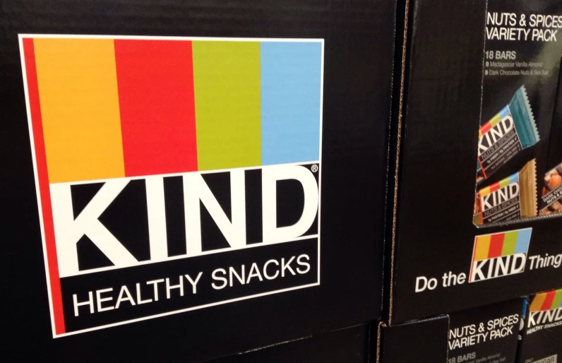 a black and green store display that says kind healthy snacks