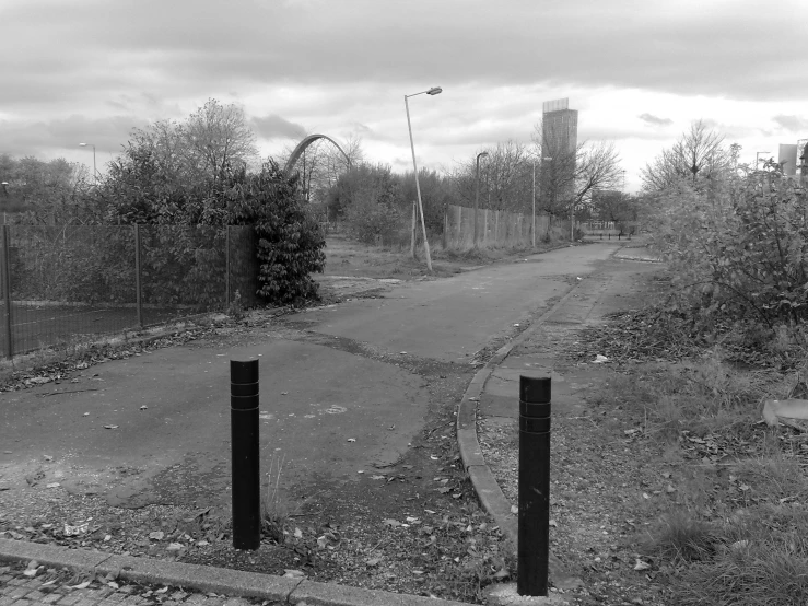 a long empty road with a gate and barbed wire on the side