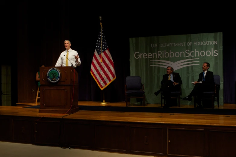 there is a man standing at a podium on stage