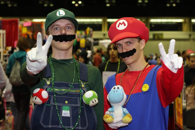 two people with fake mustaches wearing mario and luigi costumes