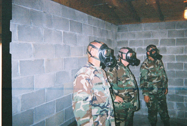 military members in gas masks standing in an abandoned area