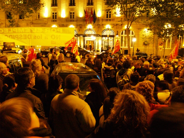 many people gathered together and a police car in front