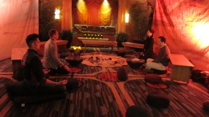 a group of people sitting on the floor in a small room