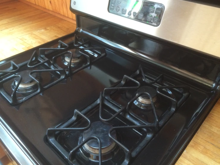 a gas stove with two burners sits on a wooden floor