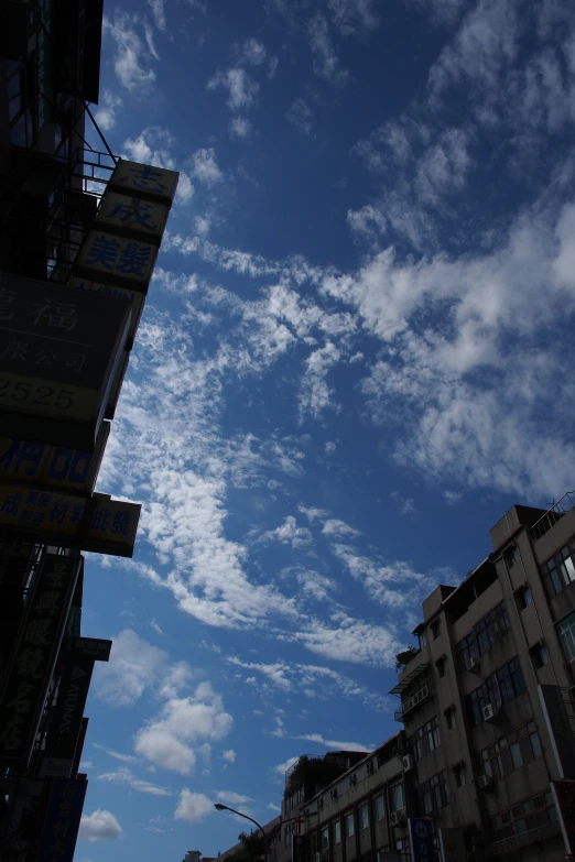 a tall building on the edge of a city street with a cloudy sky