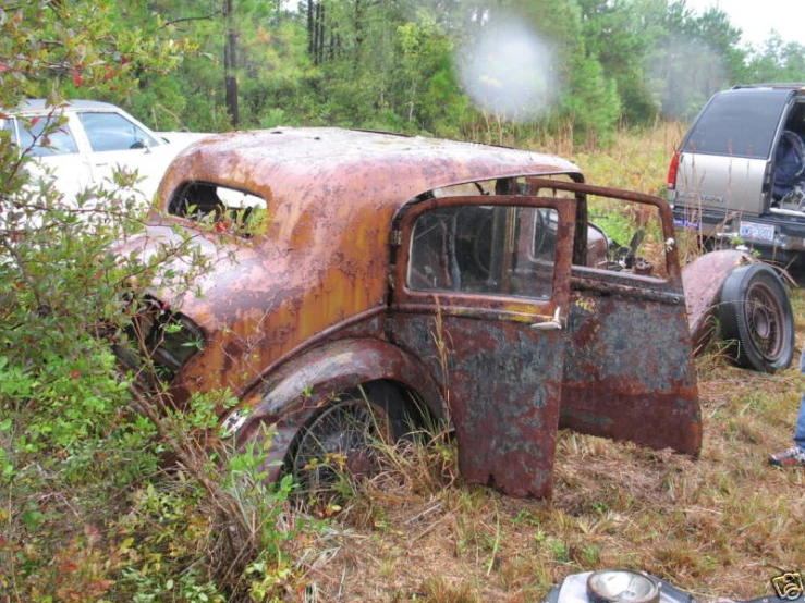 an old rusted pickup truck is sitting in the weeds