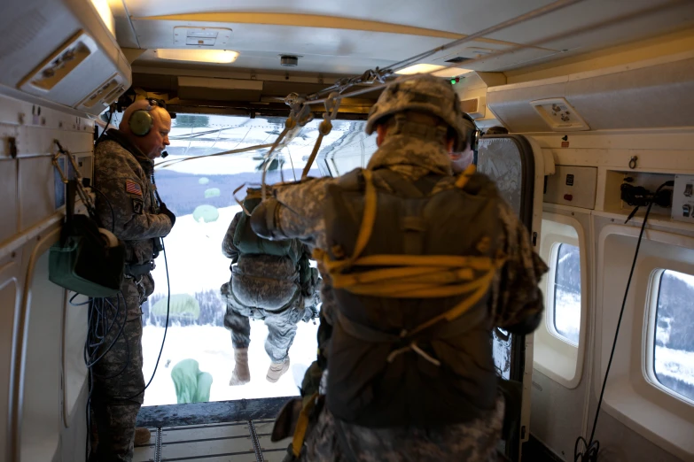 two military personnel in the back of an airplane