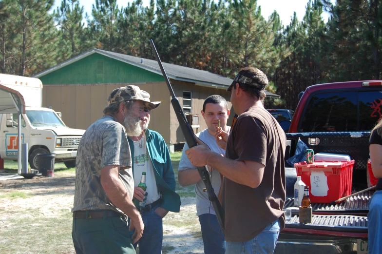 men holding guns standing next to a truck