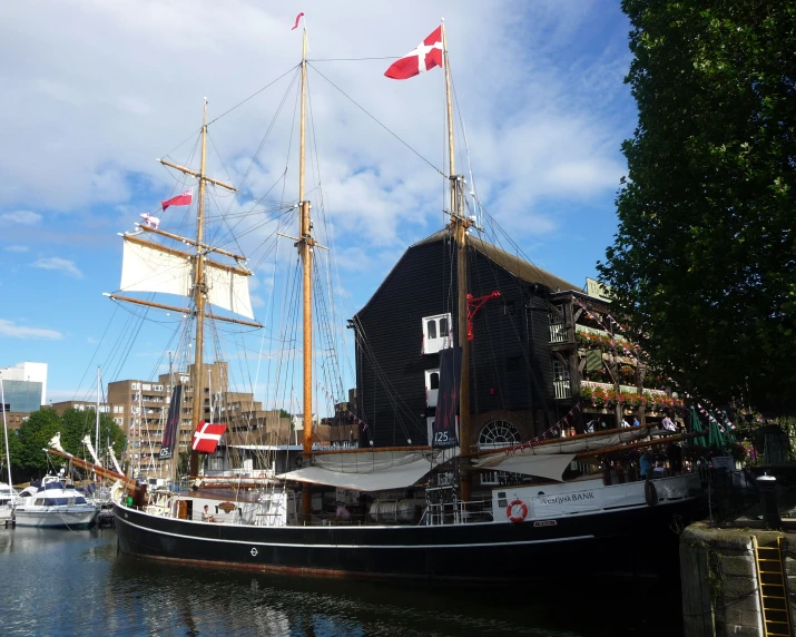 an old pirate ship in the water next to other boats