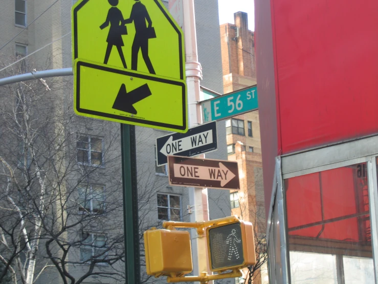 a traffic light pole with various street signs and buildings in the background