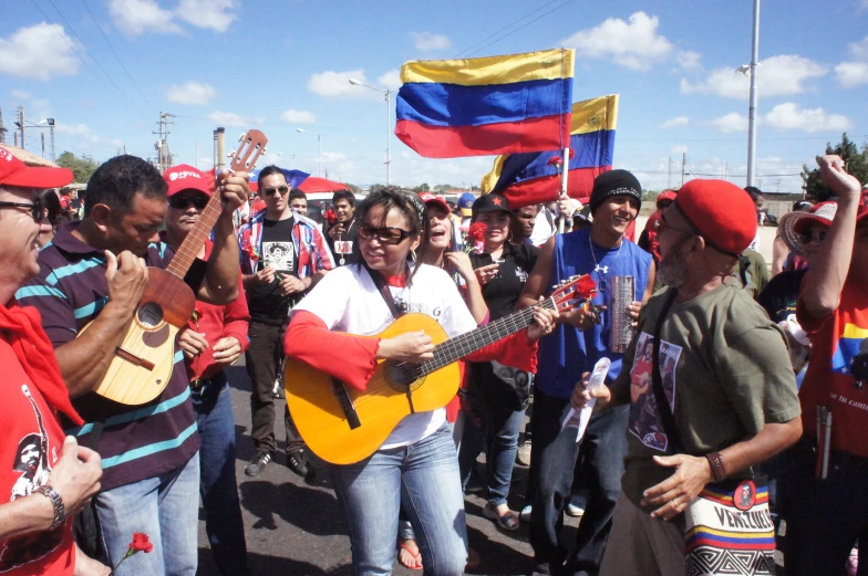 people marching down the street carrying flags and guitar