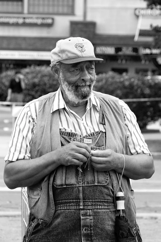 a man in overalls standing on the street