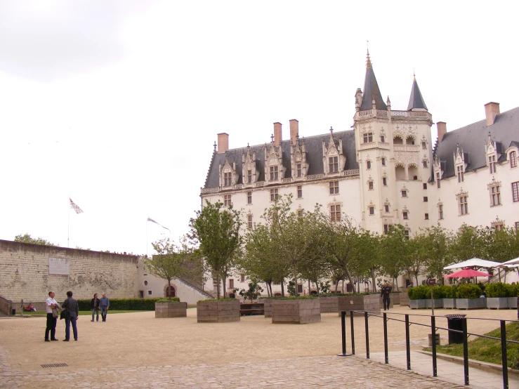 people are walking around in front of a large castle