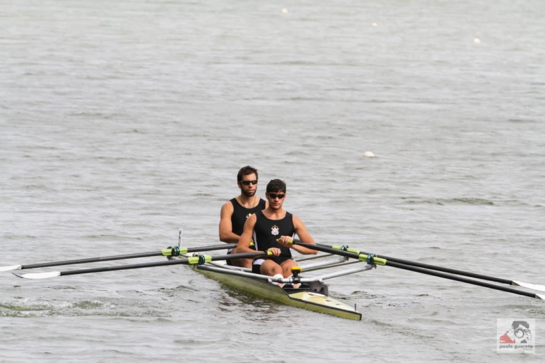 the two rowers are sitting on their boats