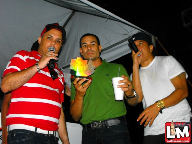 three men standing with drinks at a party