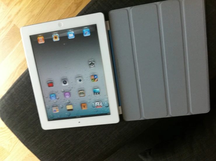 a tablet next to an ipad case on a chair