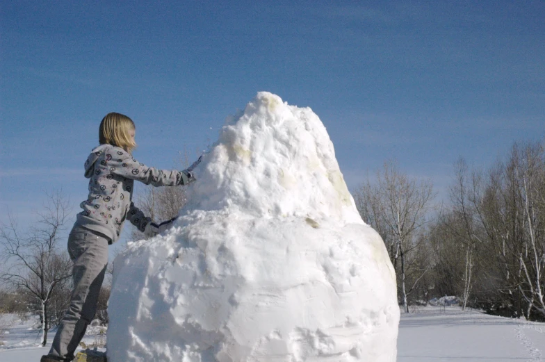 a  building a snowman outside in the snow