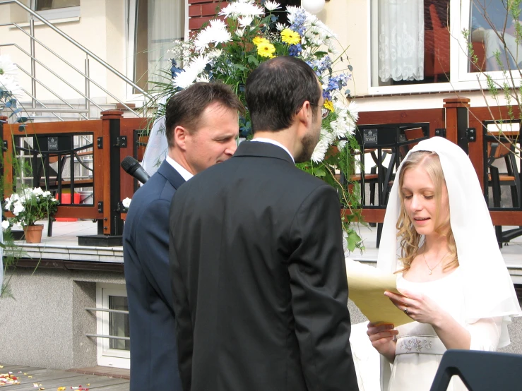 bride and groom reading vows in front of wedding couple