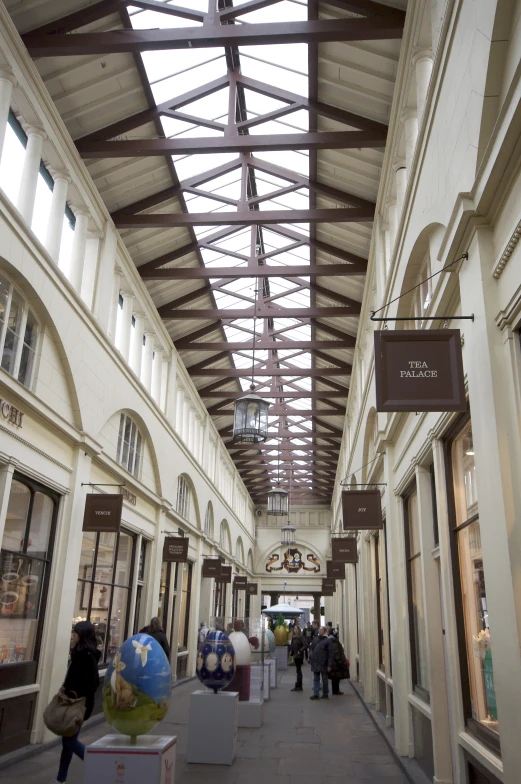 a walkway in the center of a store with glass roofs and large windows