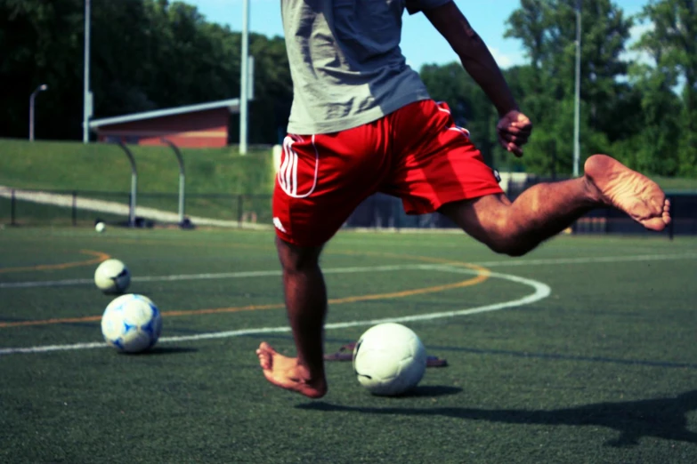 a person kicking a soccer ball in an open area