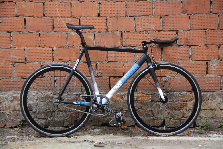 a bicycle leaning against a wall against a brick wall