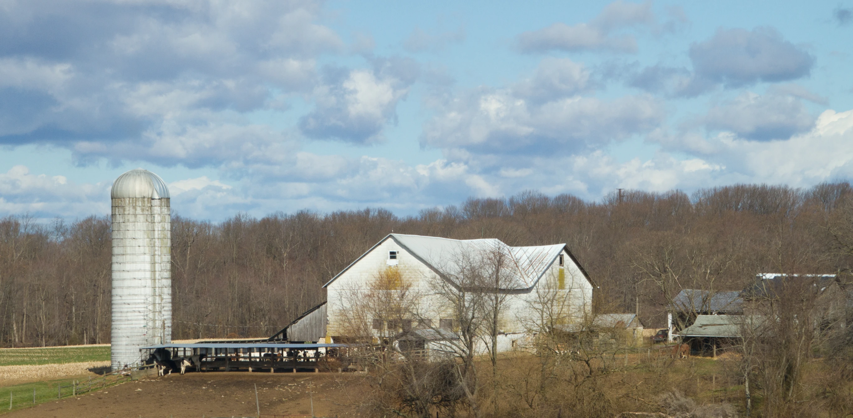 a large barn sitting next to a tall silo