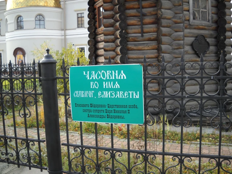 there is a sign posted on the fence of a cemetery