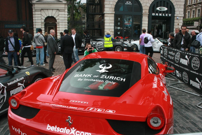 the back of a red sports car with a foreign language sign on the hood