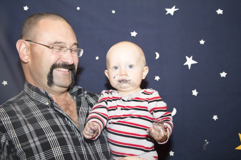 a baby being held by its father during the day