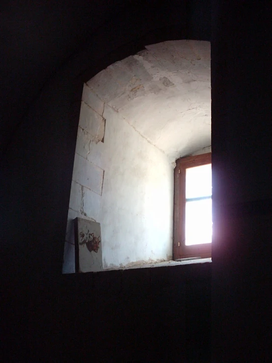 an old building with a window and light coming out