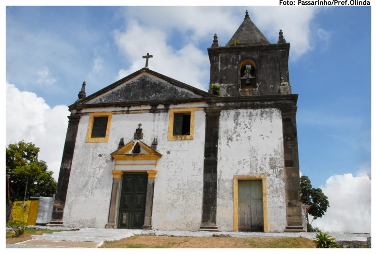 a very old building with two door and steeple