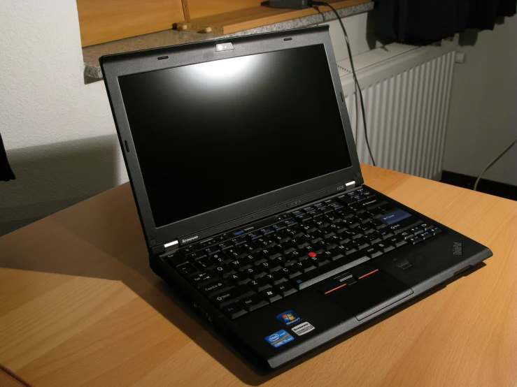 a small laptop sitting on a table in front of a light
