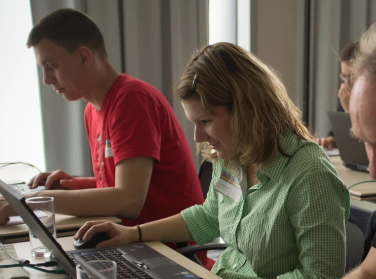 a woman using a laptop computer while others look on