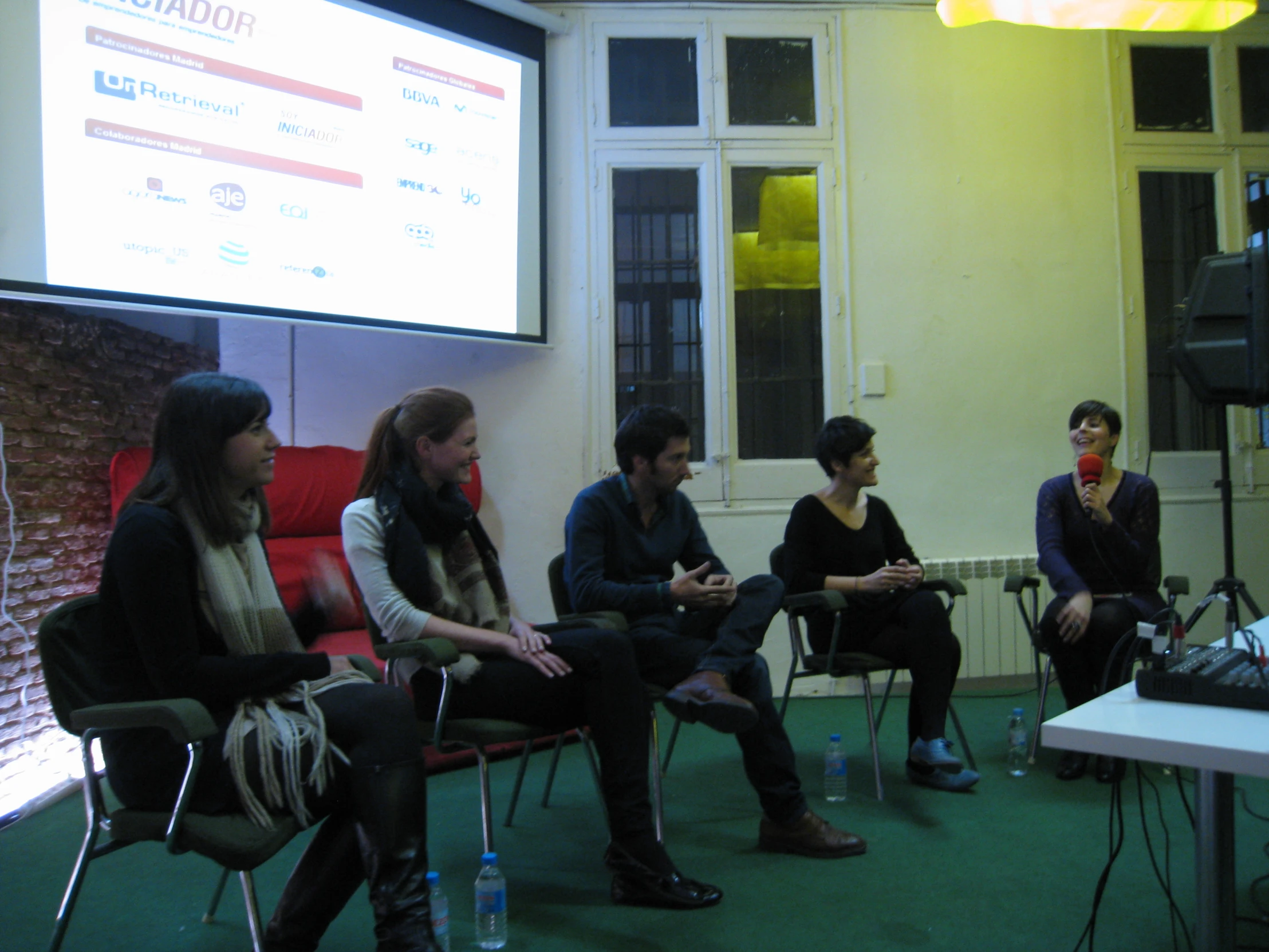 group of people sitting on chairs in front of a screen