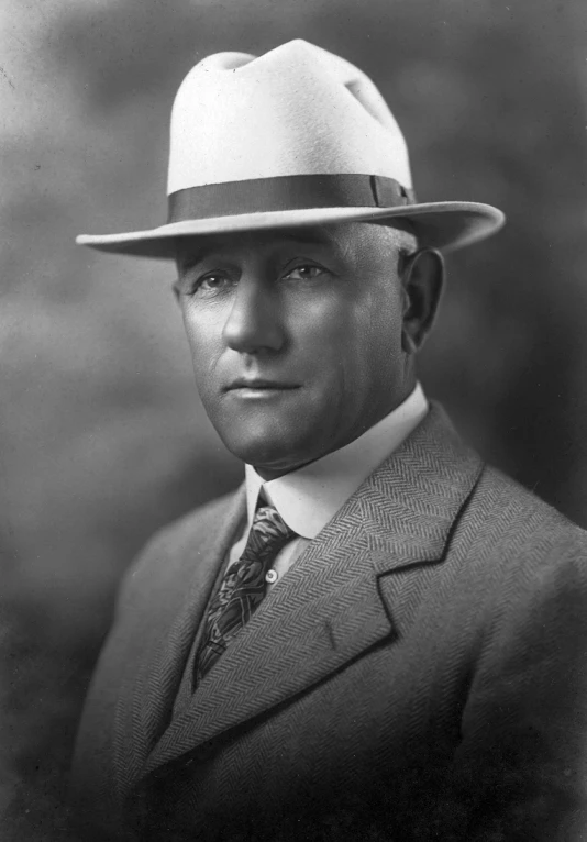 a man in suit and tie with a hat on his head