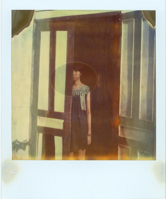 an antique pograph of a  standing in front of a window