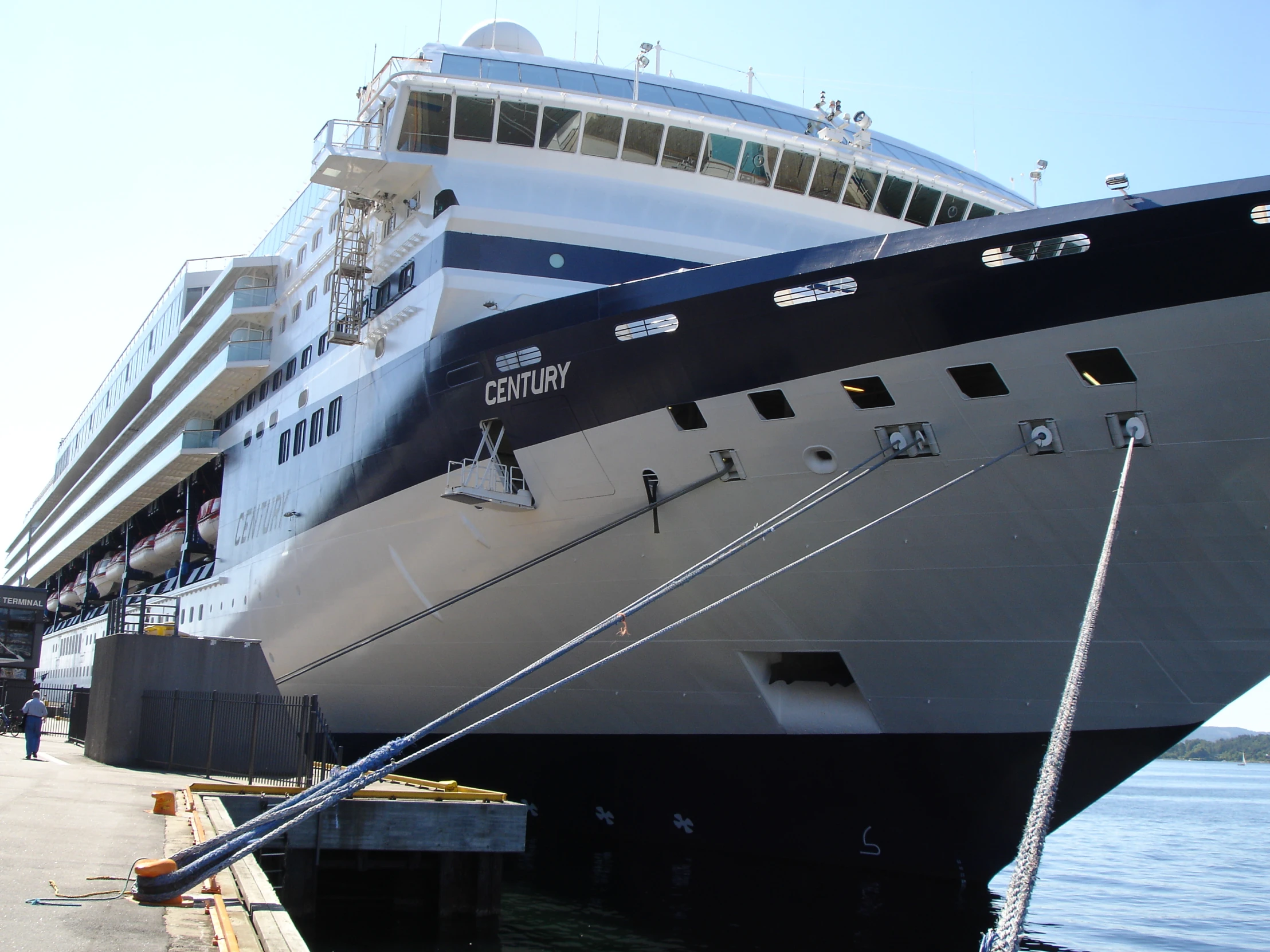 a boat docked at a busy pier near the water