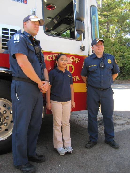 three cops standing in front of a fire truck