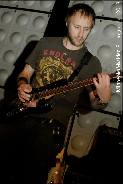 a man playing an electric guitar while singing into a microphone