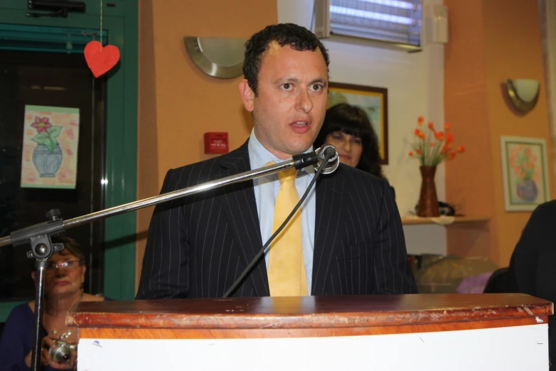 a man in a suit talking into a microphone